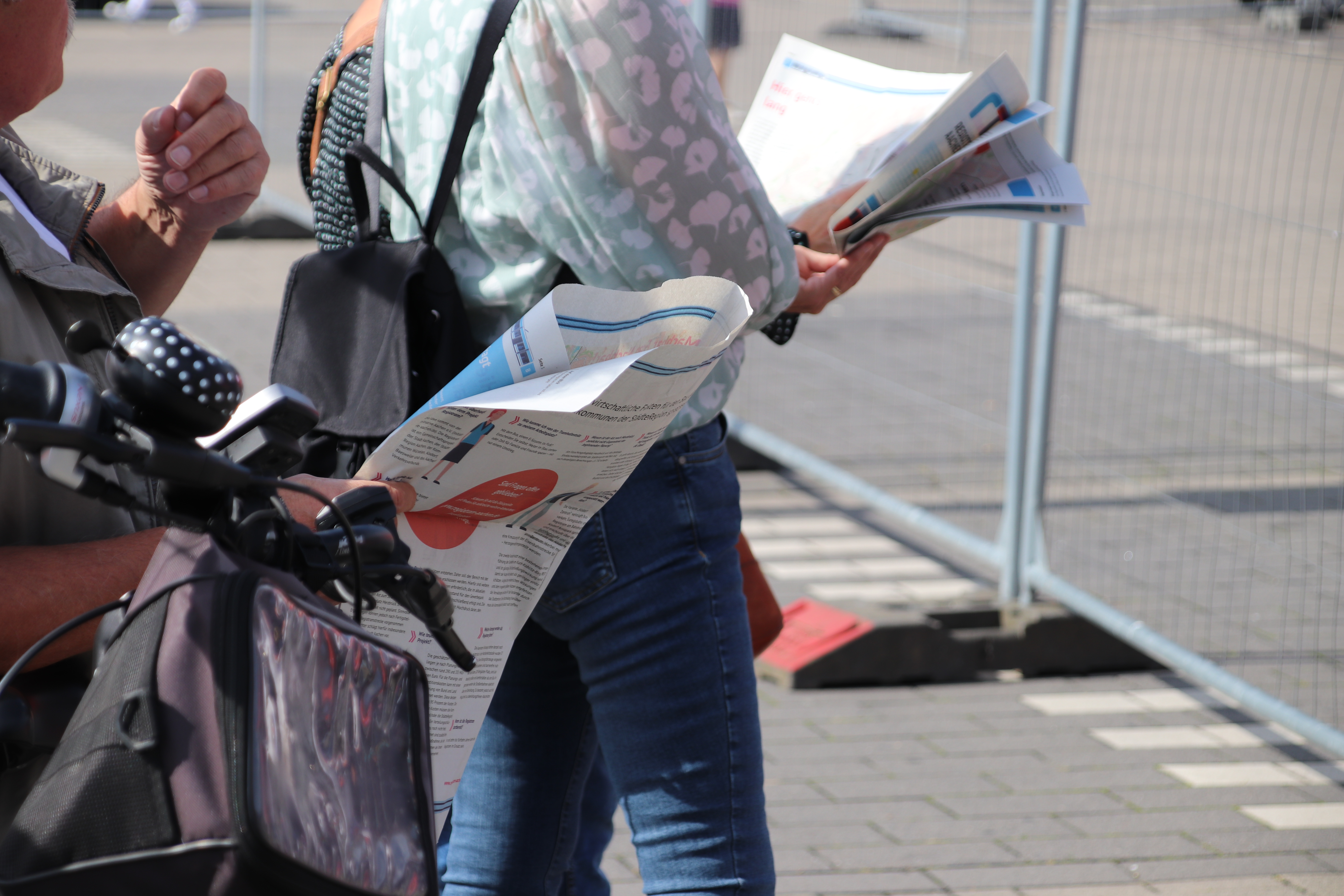 Besucher*innen lesen die Projektzeitung.