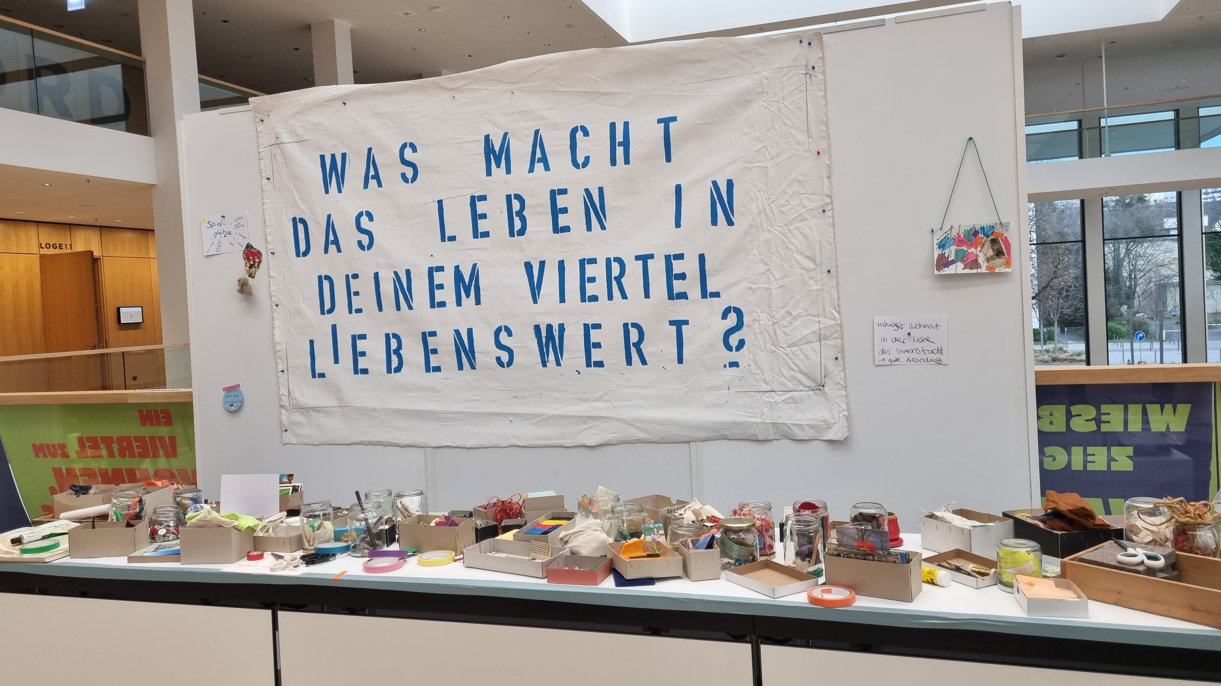 Banner über dem Atelier "Was macht das Leben in deinem Viertel lebenswert?"