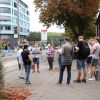 Eine kleine Gruppe Besucher*innen beim Trassenspaziergang in Aachen mit Plänen in der hand.